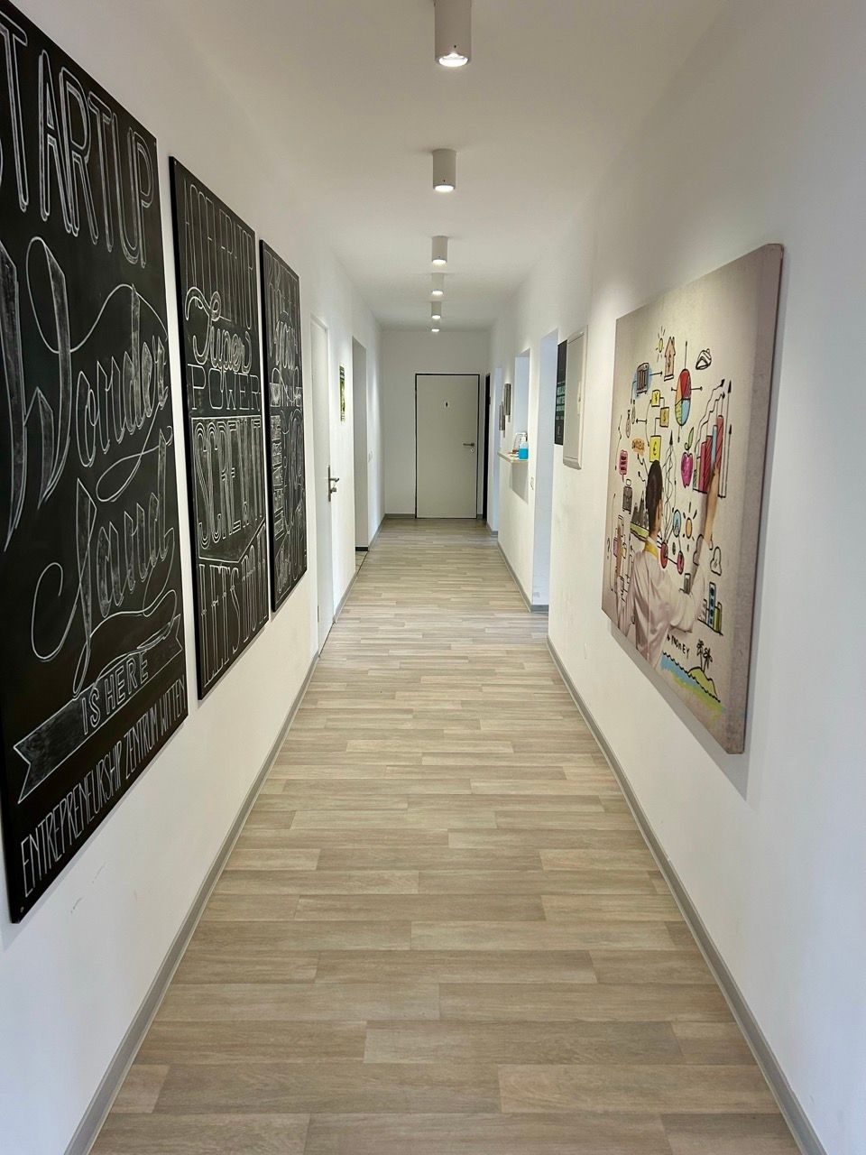 Heller Flur des Coworking Space mit Kreidetafeln an der Wand